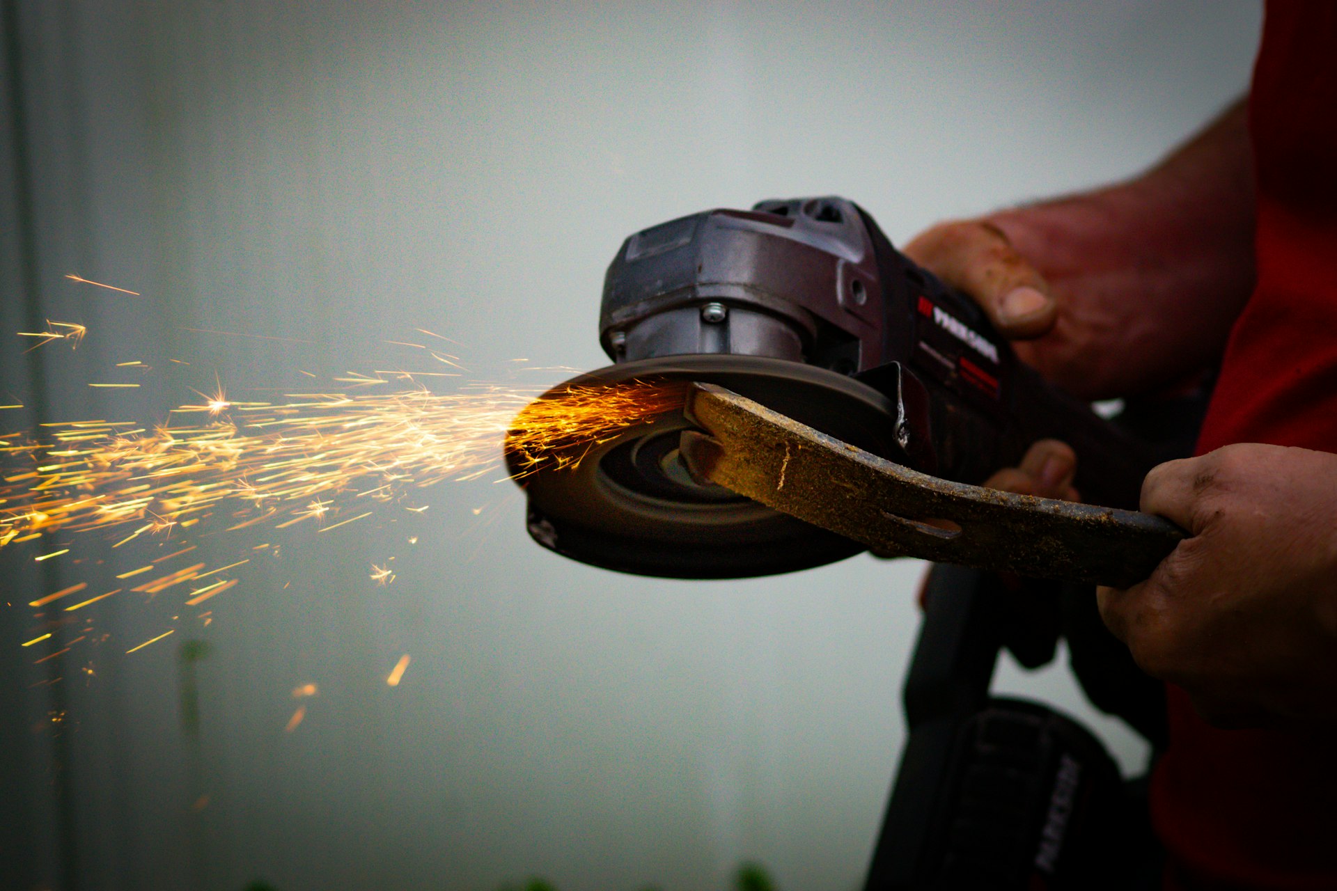 a person using a Angle Grinder on a piece of wood
